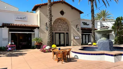 a patio with chairs and a fountain in front of a building at La Costa Escape - Pool, BBQ, Gated Parking in Encinitas