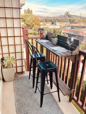 a porch with a table and chairs on a balcony at Private Balcony Overlooking Pool - Gated Parking in Encinitas