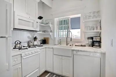 a white kitchen with white cabinets and a sink at Juniper Beach Entire Home - Sleeps 18 - Oceanfront in Carlsbad