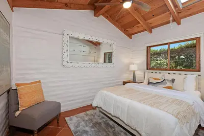 a bedroom with a bed and a chair and a mirror at Rooftop Oceanview Patio - 5BR Remodeled Home in Carlsbad