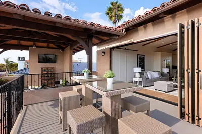 a patio with two tables and chairs on a balcony at Oceanview Rooftop Patio - Walk To The Beach & Park in Carlsbad