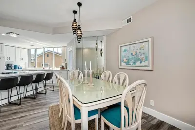 a dining room and kitchen with a glass table and chairs at 3BR Oceanview, Gated Community & Parking, Elevator in Oceanside