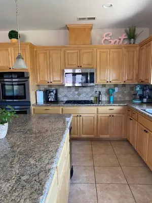 a kitchen with wooden cabinets and granite counter tops at Acres of Bliss - A hillside getaway in Ramona