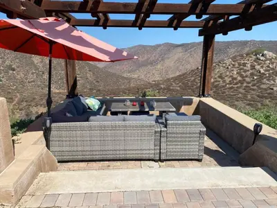 a patio with a table and an umbrella at Acres of Bliss - A hillside getaway in Ramona
