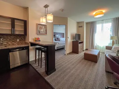 a living room with a hotel room with a bed at Staybridge Suites Carlsbad/San Diego by IHG in Carlsbad