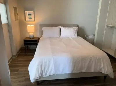 a bedroom with a large white bed with a table at Modern 2-Bedroom Apartment in Little Italy in San Diego
