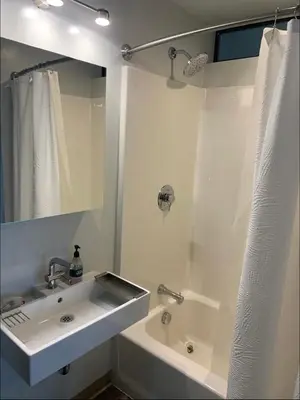 a white bathroom with a sink and a bath tub at Modern 2-Bedroom Apartment in Little Italy in San Diego