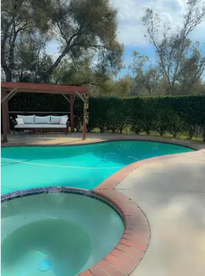 a swimming pool with a bench and a gazebo at San Diego Trail Guest Ranch in Poway