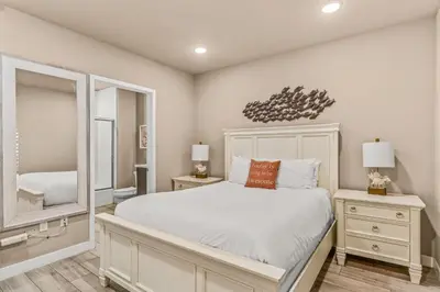 a bedroom with a large bed and two mirrors at Oceanside Escape 700S-102 in Oceanside