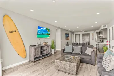 a living room with a surfboard on the wall at Oceanside Escape 700S-102 in Oceanside