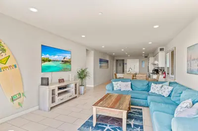 a living room with a blue couch and a surfboard at Oceanside Oasis 700S-103 in Oceanside