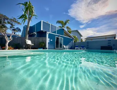 a swimming pool in front of a blue house at * - The Leucadia Beach Grotto - * An Encinitas Gem in Encinitas