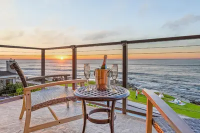 a table and chairs on a balcony with a view of the ocean at Sur La Mer, beachfront, tidal pools in San Diego