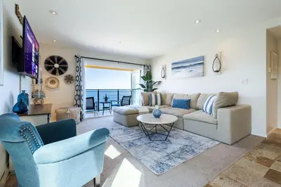 a living room with a couch and a table at Sur La Mer, beachfront, tidal pools in San Diego