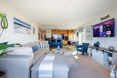 a living room with a couch and a table at Sur La Mer, beachfront, tidal pools in San Diego