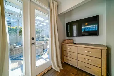 a bedroom with a dresser with a tv and a window at Panoramic Ocean Vistas With Hot Tub and Firepit in San Diego