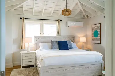 a bedroom with a white bed with blue pillows at Blue Water View Condo in Prime Coastal Locale in San Diego