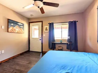 a bedroom with a blue bed and a ceiling fan at #7 Josie's Mountain Top Hideout-Cabin in the Woods in Santa Ysabel