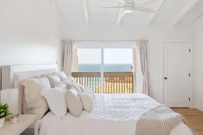 a white bedroom with a bed with a view of the ocean at Boho Solana Stunner in Solana Beach