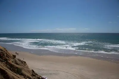 a beach with people walking on the sand and the ocean at Boho Solana Stunner in Solana Beach