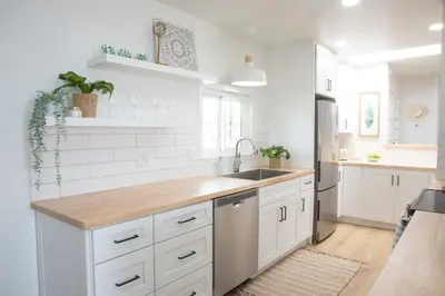 a kitchen with white cabinets and a sink at Boho Solana Stunner in Solana Beach