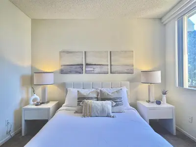 a bedroom with a large white bed with two lamps at SPECIAL OFFER - Modern Apartment in La Jolla UTC - Close to Beaches, Shopping, Dining, UCSD in San Diego