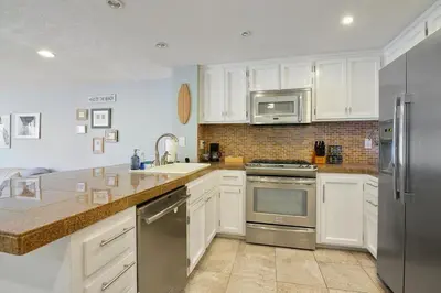 a kitchen with white cabinets and stainless steel appliances at IB Coastal Condo - Imperial Beach - Shops - Patio in Imperial Beach