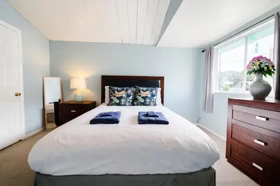 a bedroom with a large bed with two blue towels on it at Idyllic 1BR APT in Ocean Beach in San Diego