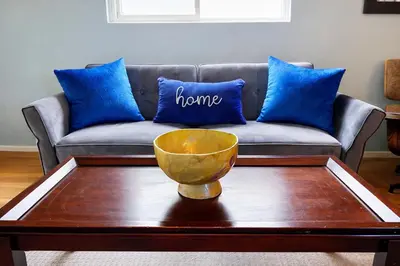 a couch with blue pillows and a bowl on a coffee table at Idyllic 1BR APT in Ocean Beach in San Diego