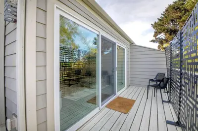 a screened porch with a chair and a large window at Sea Bluff Beach Home in Encinitas