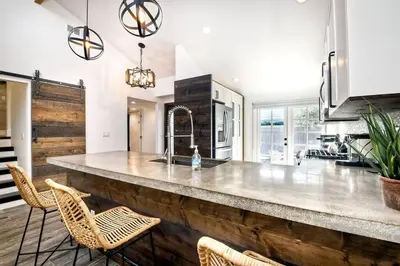 a kitchen with a large wooden counter with chairs at Sea Bluff Beach Home in Encinitas