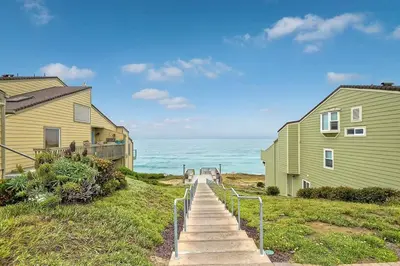 a stairway leading down to the beach between two houses at Sea Bluff Beach Home in Encinitas