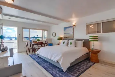 a bedroom with a large bed and a dining room at Bayside 1 in San Diego