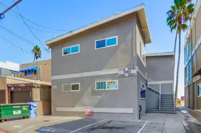 a gray building with blue windows on a street at Bayside 1 in San Diego
