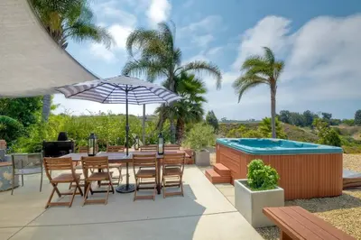 a patio with a table and chairs and a swimming pool at Nice home, Ocean views, and open space views. in Oceanside