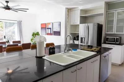a kitchen with a sink and a refrigerator at Elite Retreat! Hot Tub, Arcade, & Theater. 6 Beds! in Encinitas