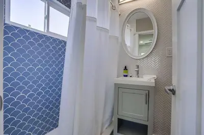 a bathroom with a white shower curtain and a sink at Bayside Bikini 2 in San Diego