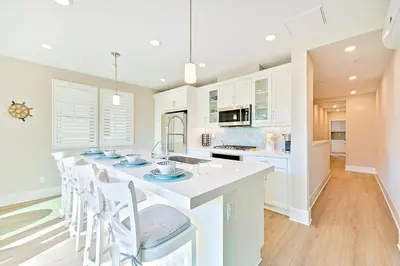 a kitchen with a large white island with chairs at Bayside Cove 4 in San Diego