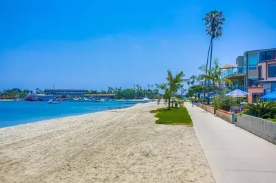 a sandy beach with palm trees and buildings at Bayside Cove 4 in San Diego