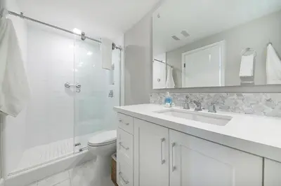 a white bathroom with a sink and a shower at Bayside Cove 4 in San Diego