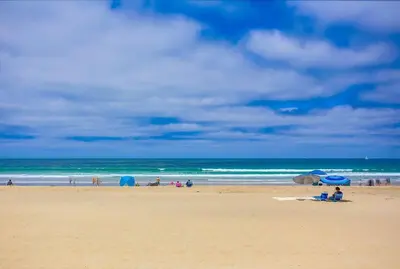 a group of people on a beach with umbrellas at Penthouse in San Diego