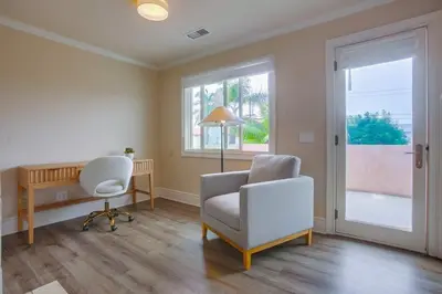 a living room with a chair and a desk and window at Grandview 2 in Encinitas