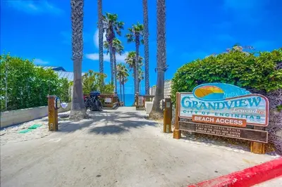 a sign for a beach house with palm trees at Grandview 2 in Encinitas
