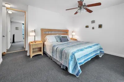 a bedroom with a bed and a ceiling fan at North Coast Village in Oceanside