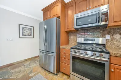 a kitchen with a stainless steel refrigerator and microwave at Giant 7 Bedroom Home with 3 separate Condos in Newport Beach