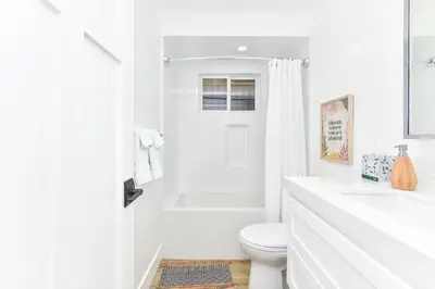 a white bathroom with a toilet and a shower at BRAND NEW Luxury 1 Bedroom Condo Steps from the Beach in Newport Beach