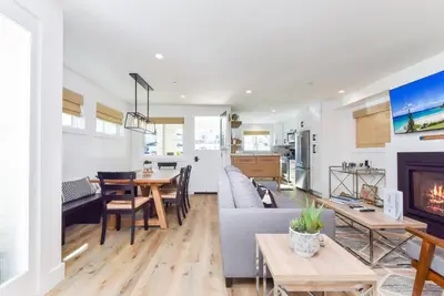 a living room with a couch and a fireplace at BRAND NEW Luxury 1 Bedroom Condo Steps from the Beach in Newport Beach