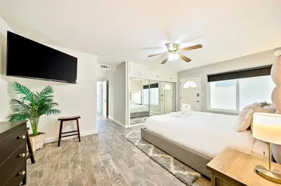 a bedroom with a large bed and a flat screen tv at Perfect 3 Bedroom Home between the Bay and Beach in Newport Beach