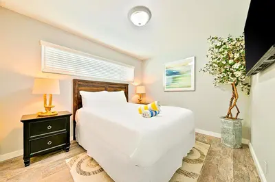 a bedroom with a large white bed and a night stand at Perfect 3 Bedroom Home between the Bay and Beach in Newport Beach