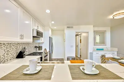a kitchen with white cabinets and two cups on a table at 6 Bedroom Home with Rooftop Deck Between the Bay & the Beach in Newport Beach